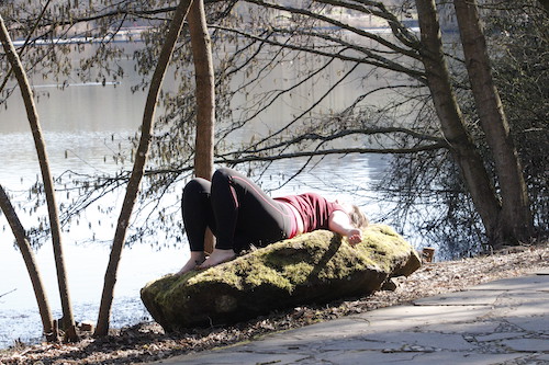 Sarah entspannt während des Slow Joggings auf einem Stein