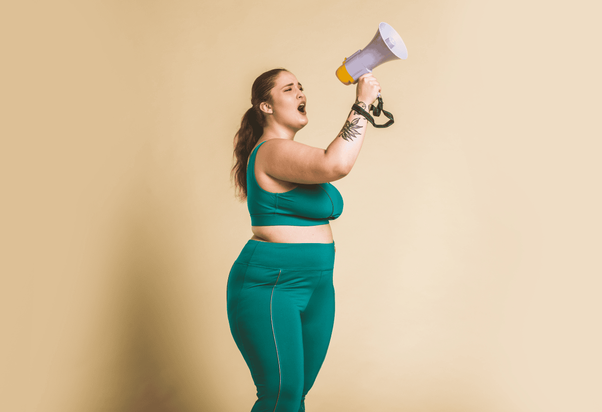 Frau in Sportkleidung ruft durch ein Megafon – Symbol für Stärke, Selbstbewusstsein und Motivation.