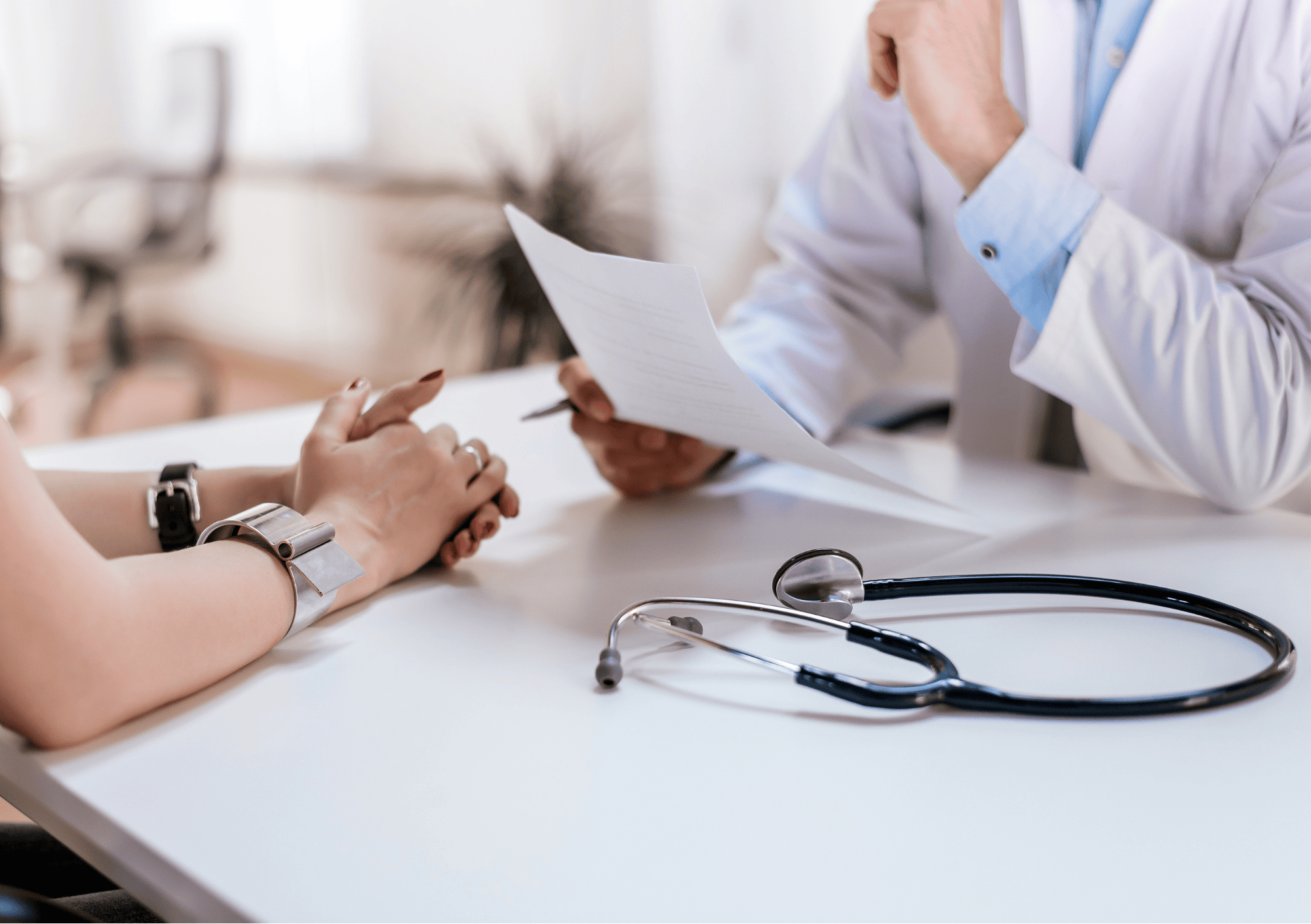 Patientin im Gespräch mit Arzt – medizinisches Aufklärungsgespräch mit Diagnoseunterlagen