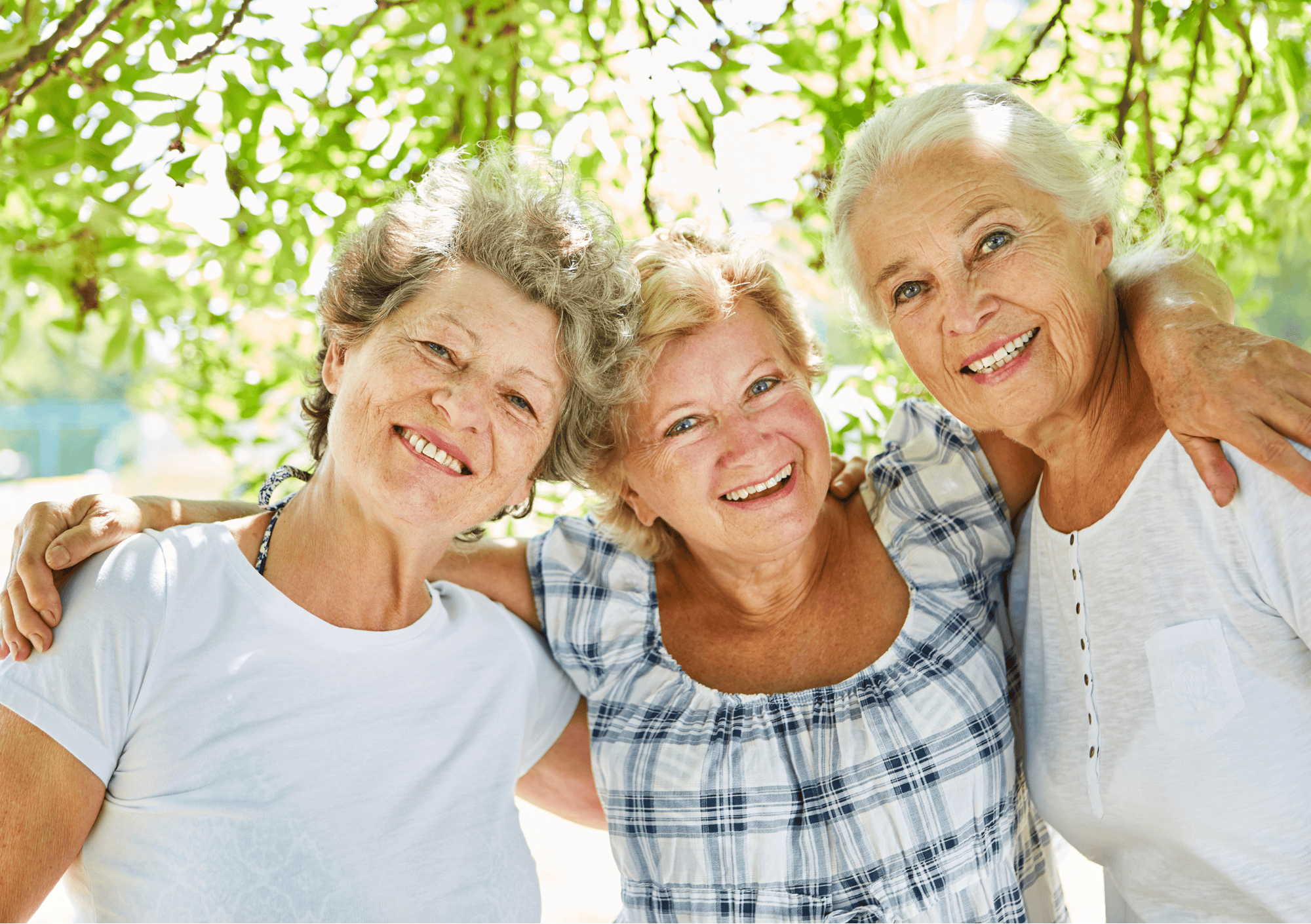 Drei ältere Frauen lachen gemeinsam – gelebte Körperakzeptanz im Alter