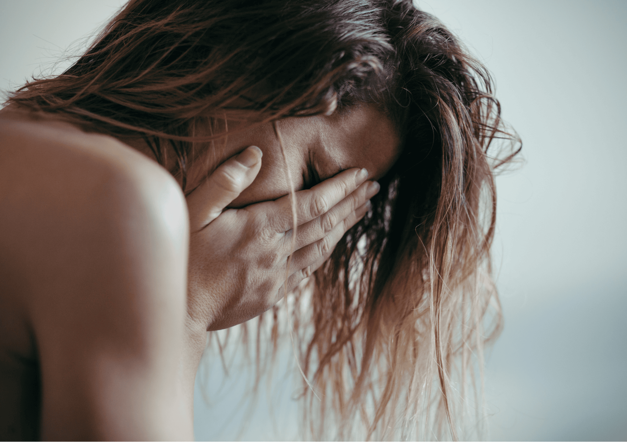 Frau hält sich das Gesicht in den Händen – Symbol für innere Belastung und Selbstzweifel