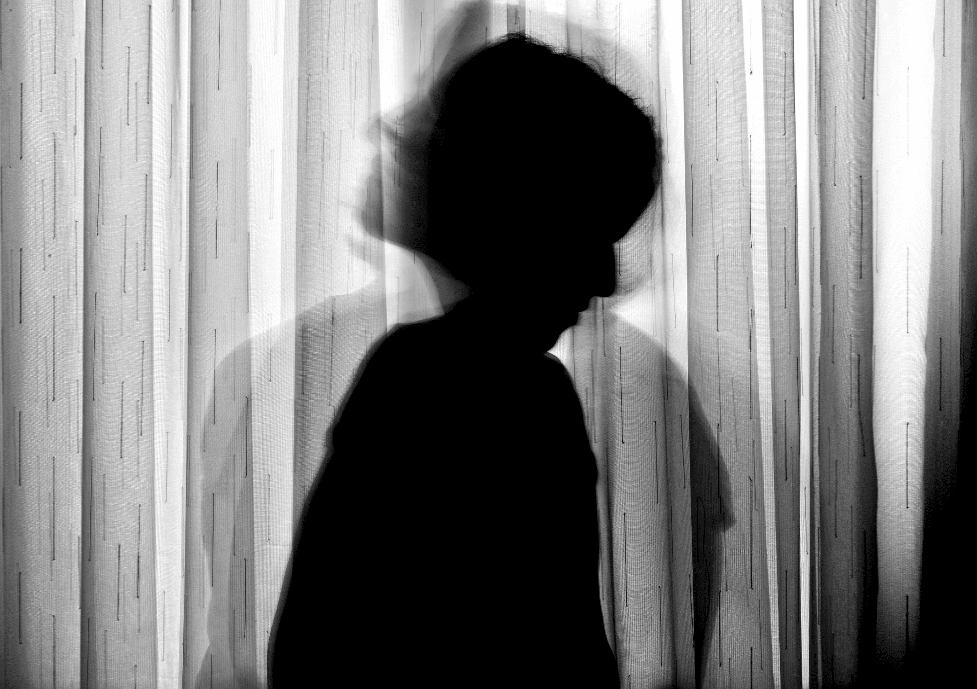 Dunkle Silhouette einer Person mit verschwommenen Konturen als Symbol für den inneren Kritiker.