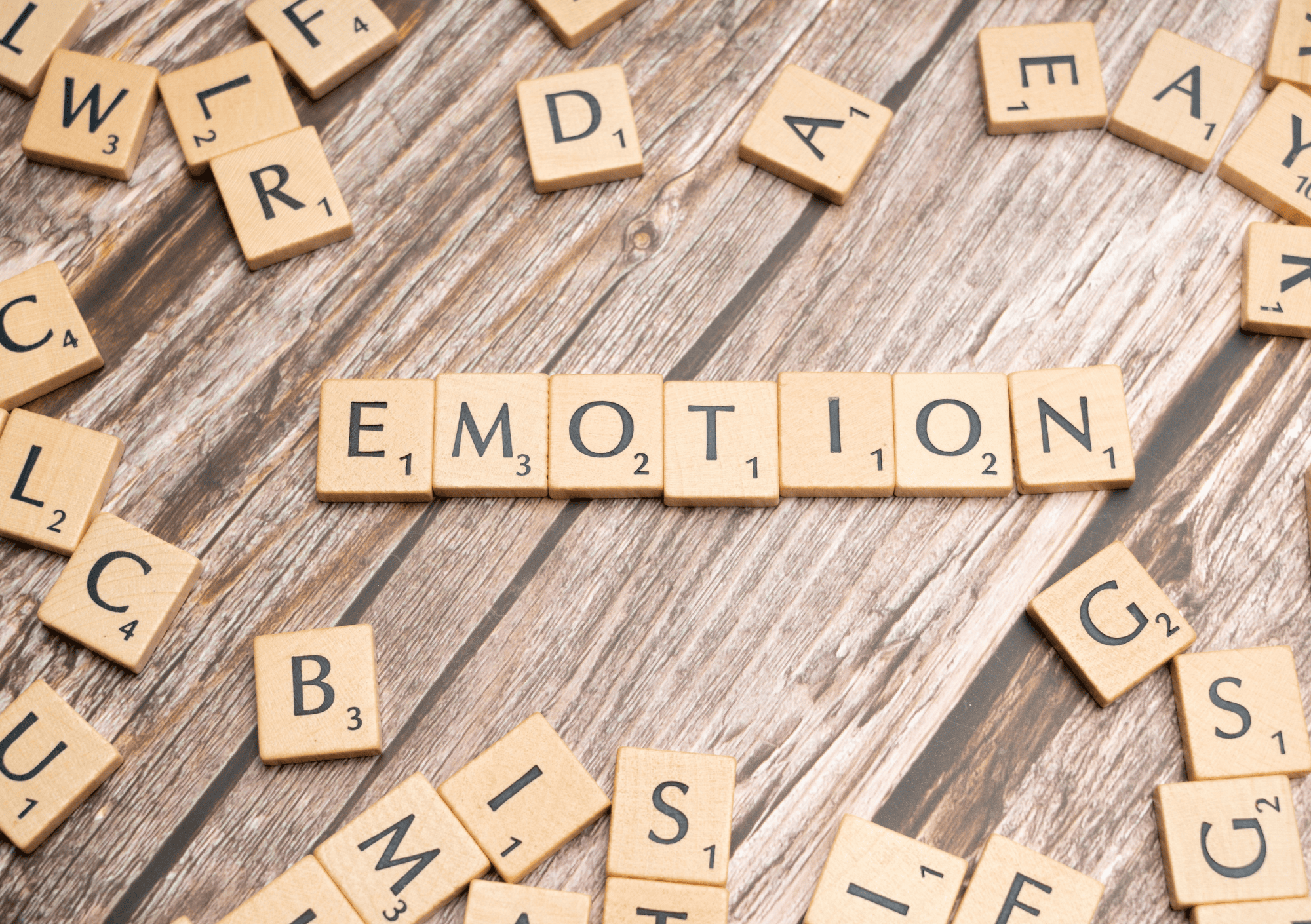 Scrabble-Buchstaben bilden das Wort Emotion – Symbol für sprachlichen Ausdruck von Gefühlen