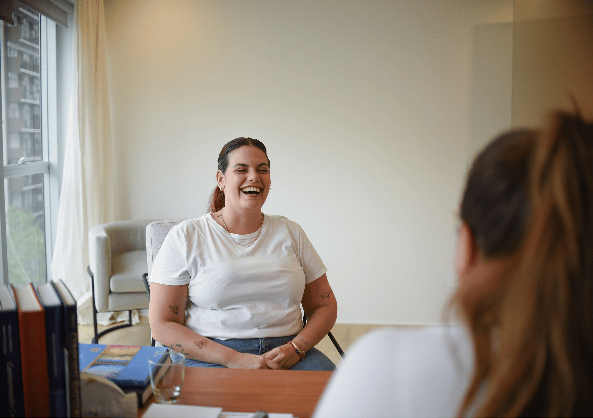 Lachende Frau im Gespräch mit Coach – positives Coaching-Erlebnis zum Thema Selbstliebe